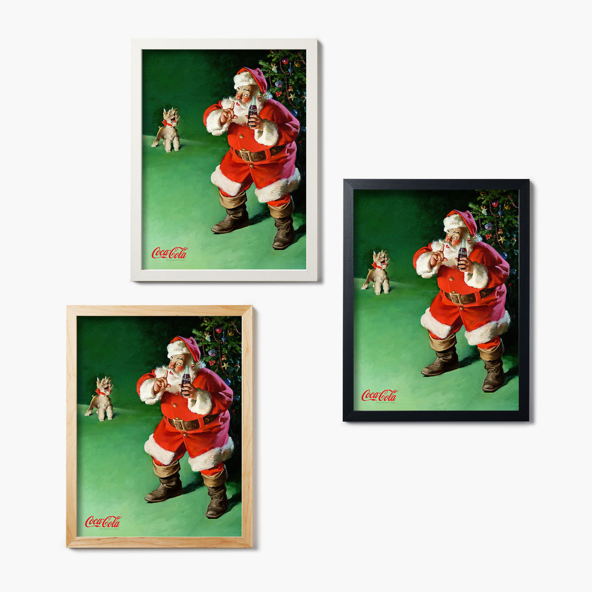 Three framed Coca-Cola glass prints featuring vintage Santa Claus in front of a Christmas tree, shushing a dog, on a white background
