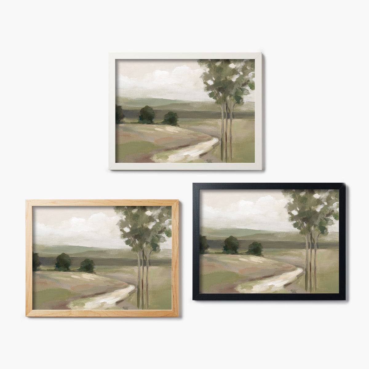 Three framed glass prints of a landscape painting with different frames on a white background